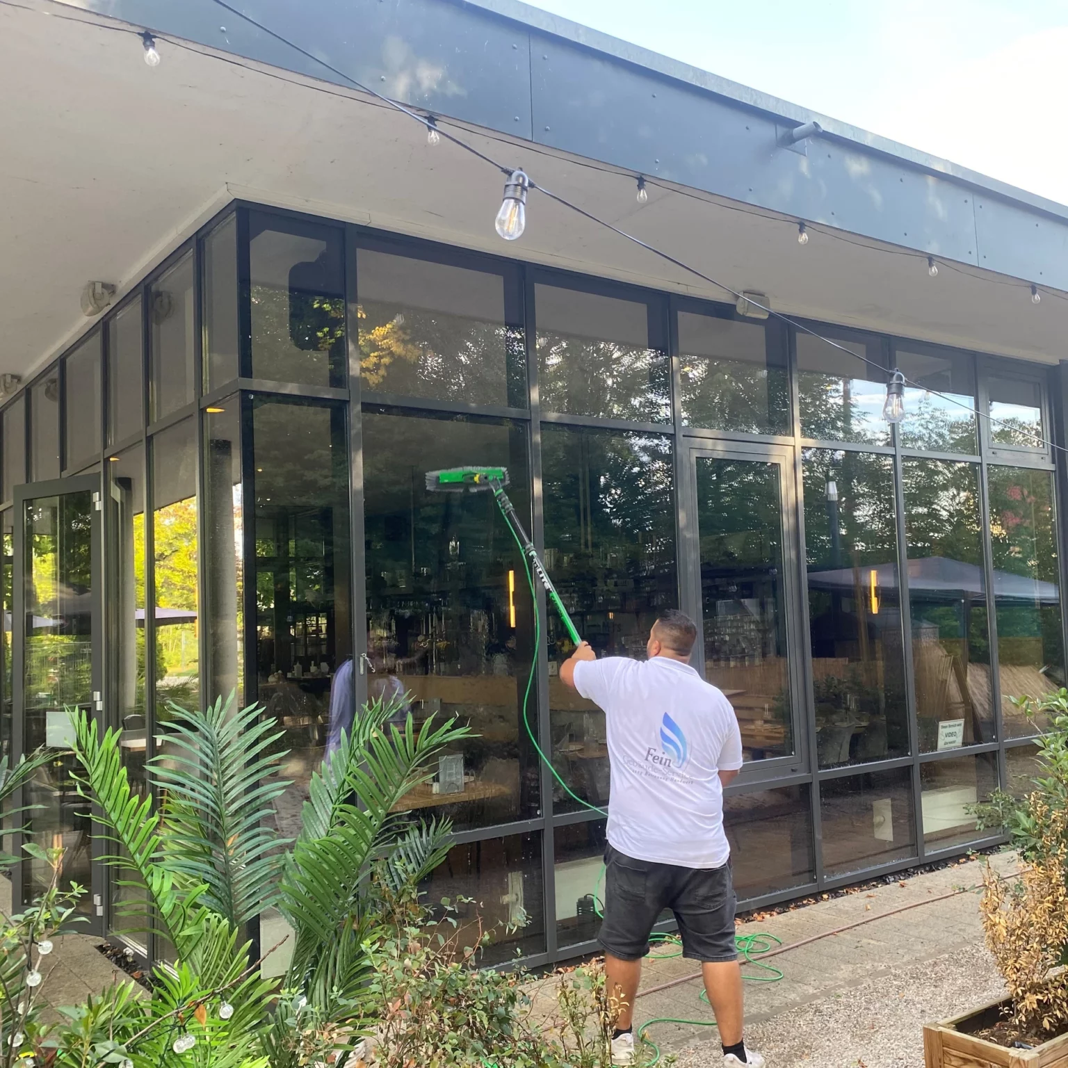 Mitarbeiter putzt große Fenster